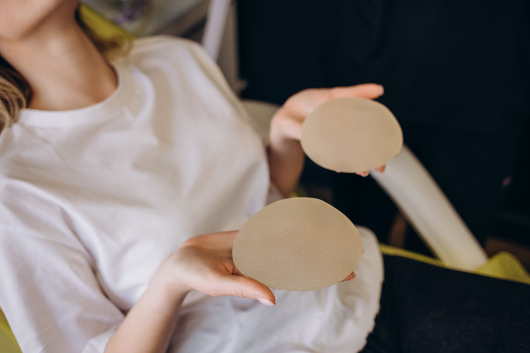 Cosmetic surgeon shows female patient breast implant samples for her future surgery