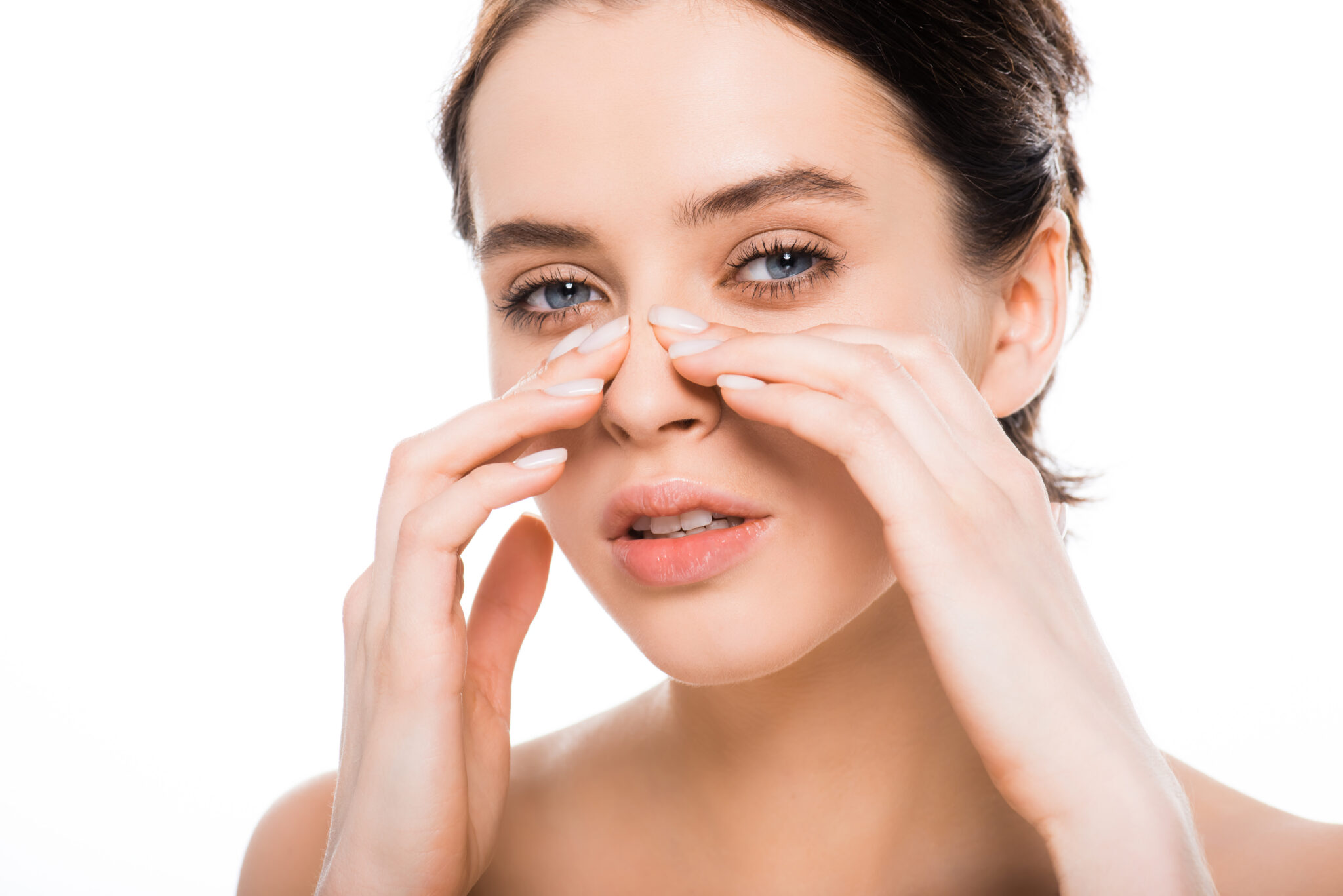 rhinoplasty recovery timeline chicago healing process Woman gently touching her nose bridge with both hands, illustrating post-operative care and the rhinoplasty recovery process